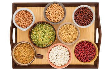 Variety of protein products for vegetarians. Soy, lentils, peas, chickpeas and various types of beans in bowls on a tray. Isolated on a white background.