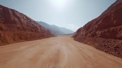 Naklejka premium Aerial view of iron ore deposits embedded in red earth, under a clear sky, with empty space above for text and promotional materials