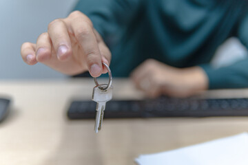 Close-up of businessman handing over key in office, business and housing concept