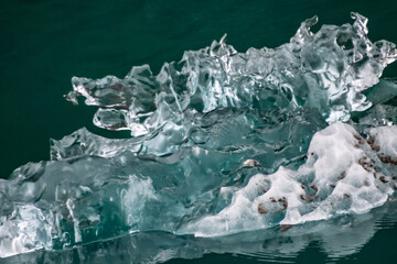 Glacier Ice adrift in the ocean, mid melting. Beautiful wild organic shape forms, including lots of expressive shapes, reflections, and color variation.