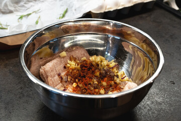 metal bowl with mincemeat with ingredients to mix to cook cutlets or meatballs, recipe.