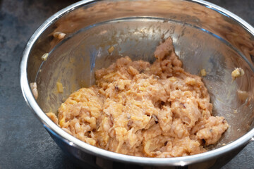 metal bowl with mincemeat mixed with ingredients to mix to cook cutlets or meatballs, recipe.