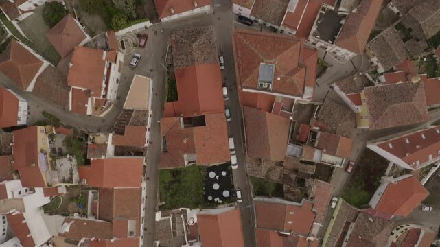 Top down birdseye aerial of Monchique's red roofed buildings and streets in Portugal. High angle view.