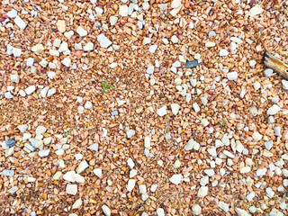 Detailed texture of gravel surface showcasing various sizes and colors of stones, ideal for landscaping or construction projects