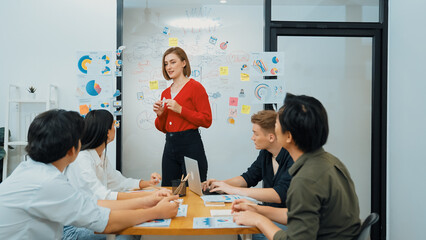 Fototapeta premium Young beautiful leader presents marketing strategy while expert investor and project manager listening and lecturing to analyze business performance at start up business meeting. Immaculate.