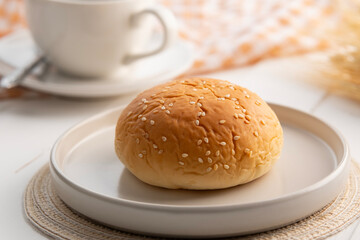 Close up red bean filled bun with White Sesame in white plate.
