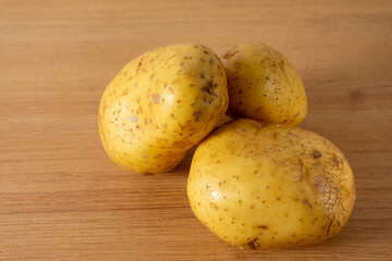 raw white potatoes scattered on a clean kitchen countertop, ready for cooking. Natural light enhances the smooth texture and earthy tones of the potatoes.