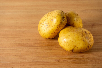 raw white potatoes scattered on a clean kitchen countertop, ready for cooking. Natural light enhances the smooth texture and earthy tones of the potatoes.