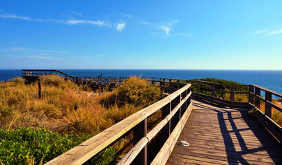 Fototapeta premium wooden walkway on algar seco amidst beautiful rock formations in Carvoeiro, Lagoa, Algarve, Portugal