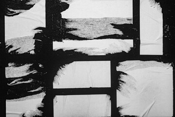 Several old street posters on a black wall.