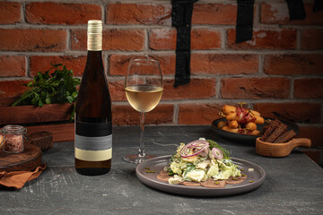 Portion of salad with iceberg leaves and beef tongue with wine