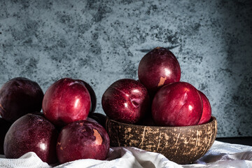 Juicy Summer Plums: Fresh Red and Black Plums on a Rustic Wooden Background