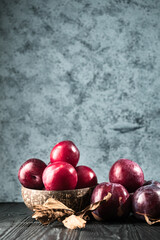 Juicy Summer Plums: Fresh Red and Black Plums on a Rustic Wooden Background