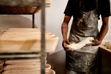 Black man, hands and bakery with dough for bread, rolls or pastry production at storage warehouse. Closeup, male person or baker with flour, ingredients or wheat for handmade food or heast at factory
