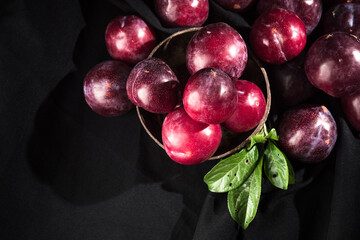 Juicy Summer Plums: Fresh Red and Black Plums on a Rustic Wooden Background