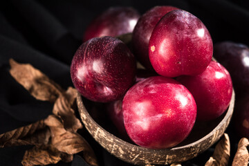 Juicy Summer Plums: Fresh Red and Black Plums on a Rustic Wooden Background