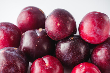 Isolated Summer Plums: Fresh and Juicy Red and Black Plums on a White Background