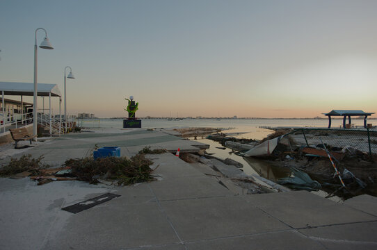 Beach damaged storm surge  after hurricanes Helene and Milton at Gulfport Beach in Florida. Ruts, gulleys,  water channels and debris in sand Late afternoon Sun with room for copy. Blue Skies and bay 