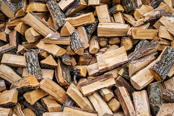 Man's Hands Stacking Chopped Firewood in a Woodpile Outdoors in Rural Countryside Background