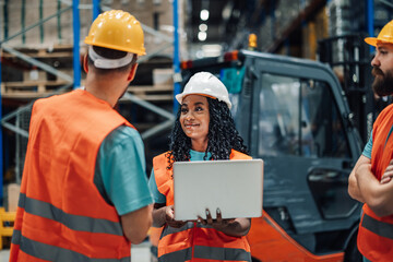 Warehouse workers having a meeting using laptop computer