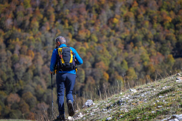 Hiker explores the mountain trail in the autumn season.