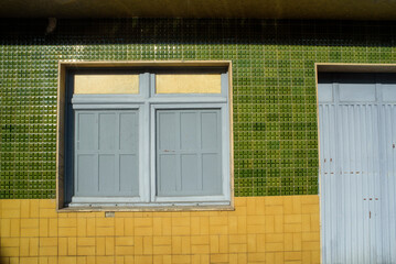 Puerta y ventana en fachada de azulejo de casa de pueblo