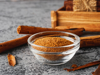 Closeup of Aromatic Ground Cinnamon and Sticks on a White Background