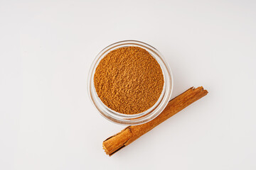 Closeup of Aromatic Ground Cinnamon and Sticks on a White Background