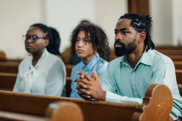 African american family praying together in church pew