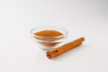 Closeup of Aromatic Ground Cinnamon and Sticks on a White Background