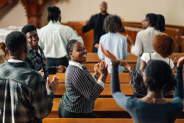 Group of people clapping hands and singing gospel music in church