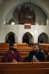 Two men having a serious conversation in church