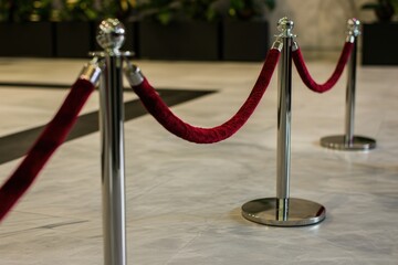 Red rope barriers on marble floor