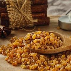 Natural Aromatic Frankincense and Myrrh Resin with Wooden Spoon on Rustic Table