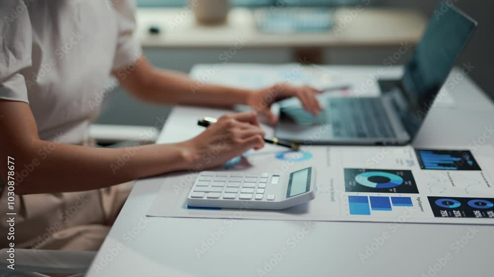 Poster accountant is calculating financial data for a company using a calculator, a laptop and printed char