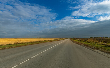 A long, empty road with a clear blue sky above