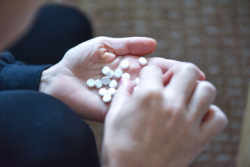 A woman holds several tablets in her hand