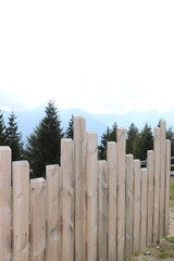 Blick auf die Berge durch einen Holzzaun.