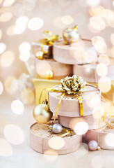 Christmas or New year round kraft gift boxes, gold holiday balls on a bokeh background of twinkling party lights of garland
