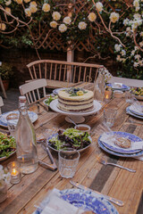 table setting in a restaurant food and cake flowers glass bottles of water whimsical garden ambience 