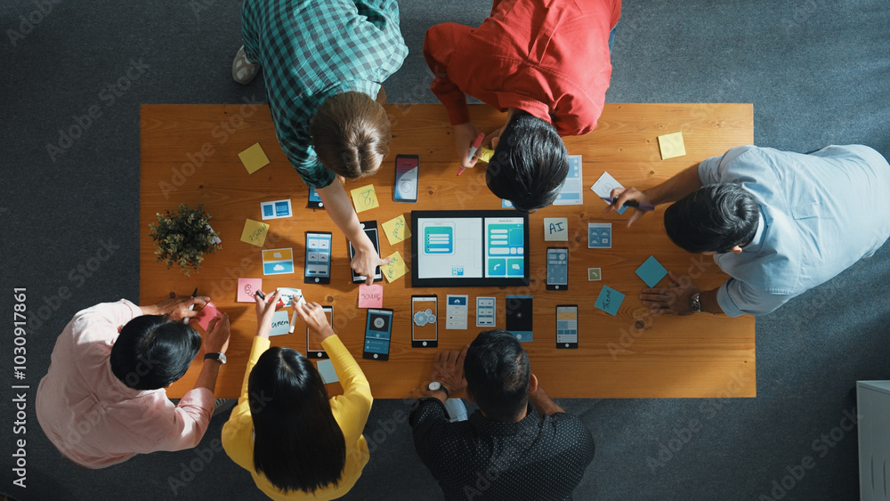 Poster top view of software developer team looking ux ui design for mobile phone interface from tablet whil