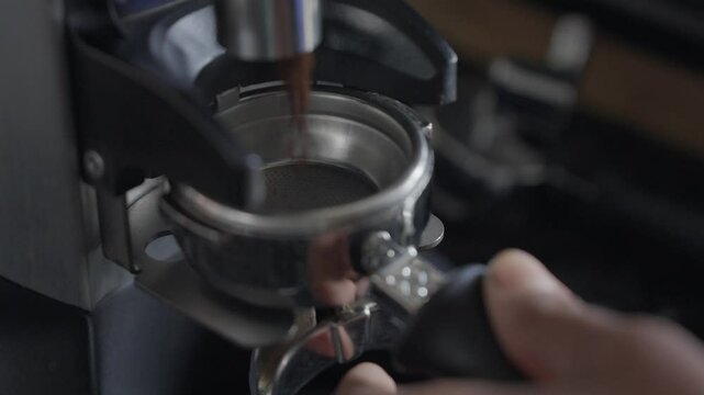 Closeup of a barista hand putting portafilter in a coffe machine