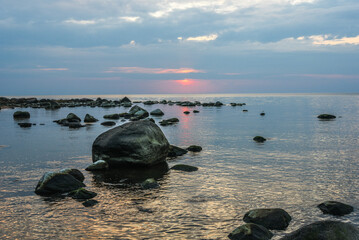 Empty Baltic sea beach full of stones during the sunset at Autumn