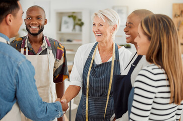 Creative, handshake and discussion with client, group and agreement in workshop, fashion designer and apron. Tailor, holding hands and people in business meeting and collaboration in design studio