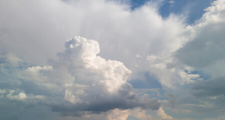 Beautiful cumulus clouds in a bright blue sky create a stunning natural backdrop, ideal for landscape and weather-related projects.