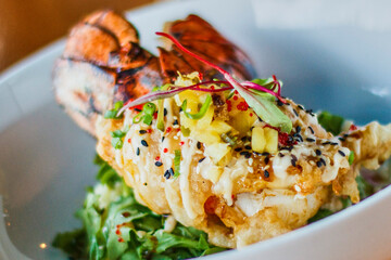 tempura fried lobster tail served with a salad