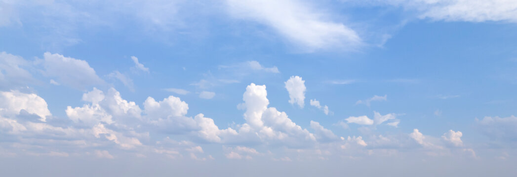 A serene view of a clear blue sky adorned with fluffy white clouds, creating a peaceful atmosphere ideal for backgrounds and nature-themed projects.