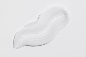 White beauty cream smear smudge on white background. Cosmetic skincare product texture. Face cream, body lotion swipe swatch