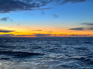 Colourful sunset over the horizon cruising an ocean. No people. Travel concept.