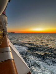 Colourful sunset over the horizon cruising an ocean on a cruise ship. No people. Travel concept.